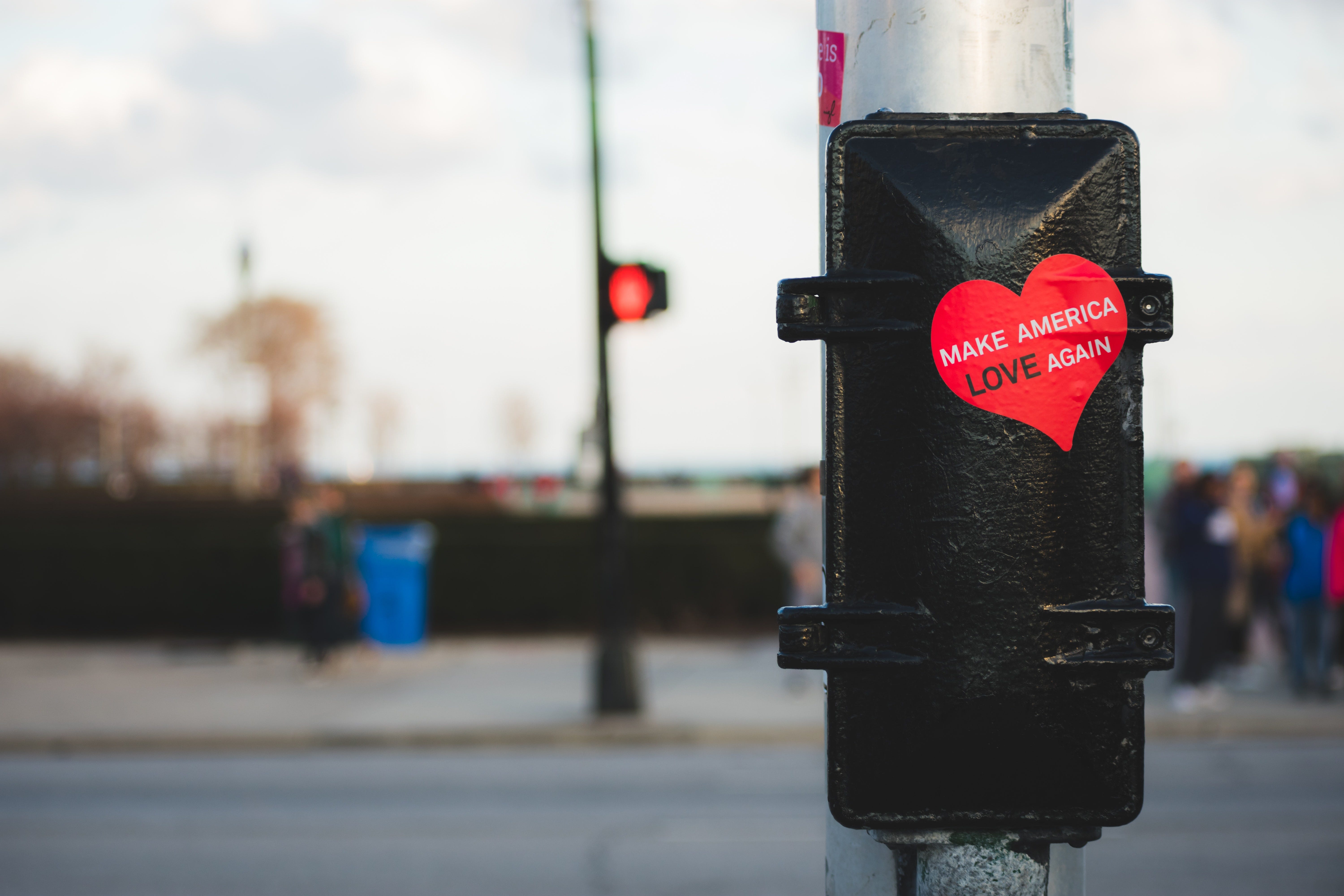 Sticker with “Make America Love Again” stuck to a black metal frame on a light pole