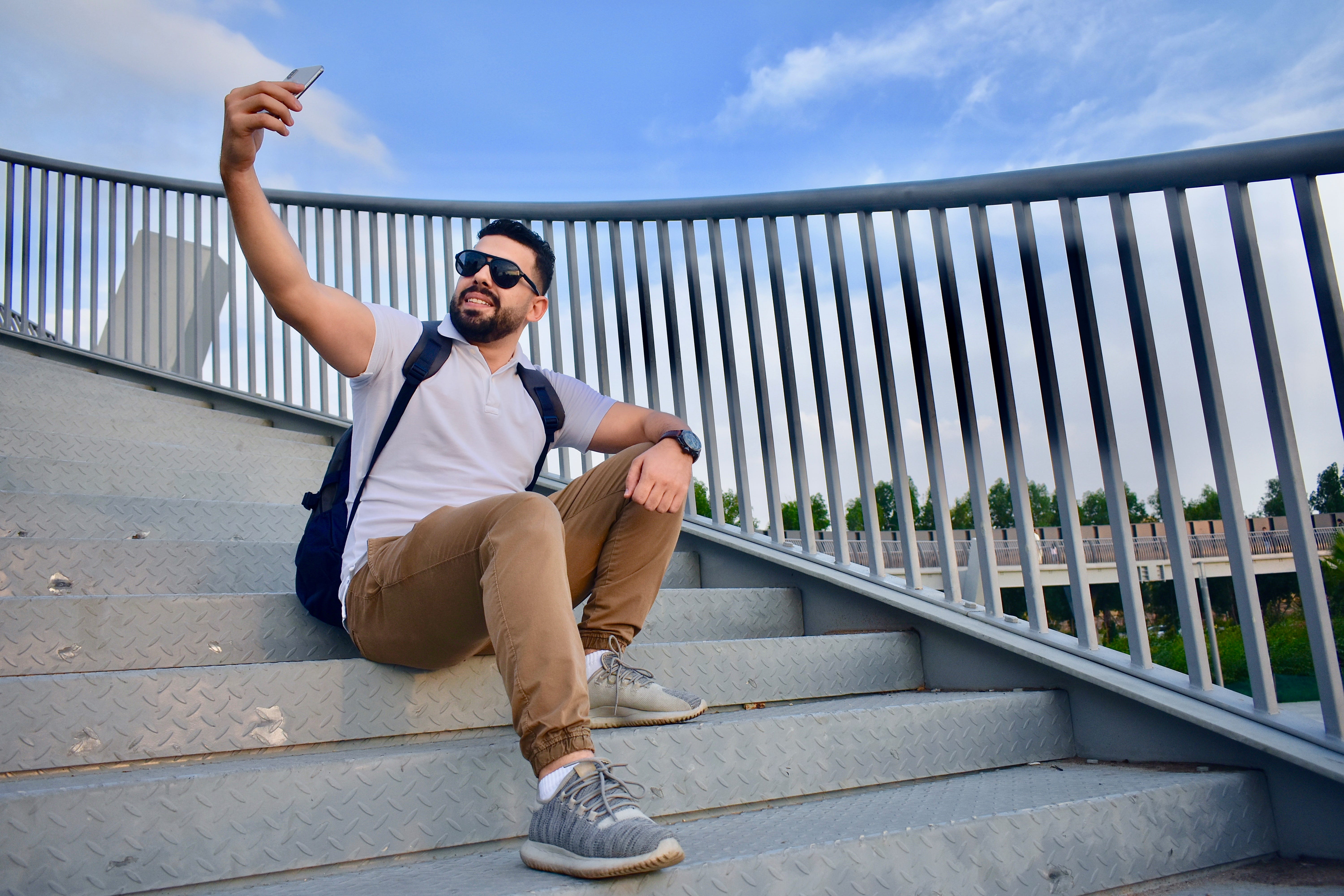An Arab man taking a selfie in the footbridge staircase