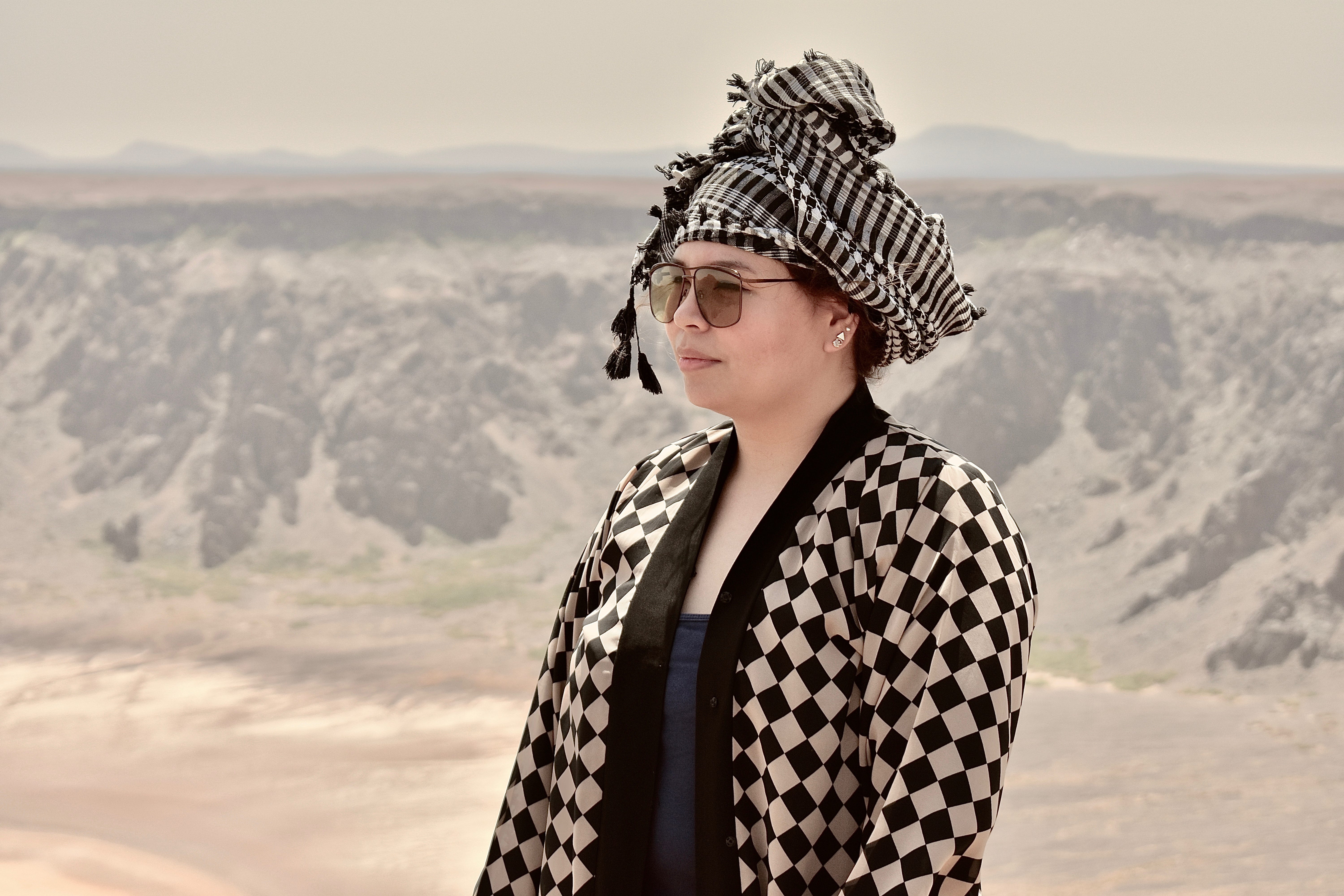 A beautiful tourist standing at the top of a passive volcanic crater in Saudi Arabia