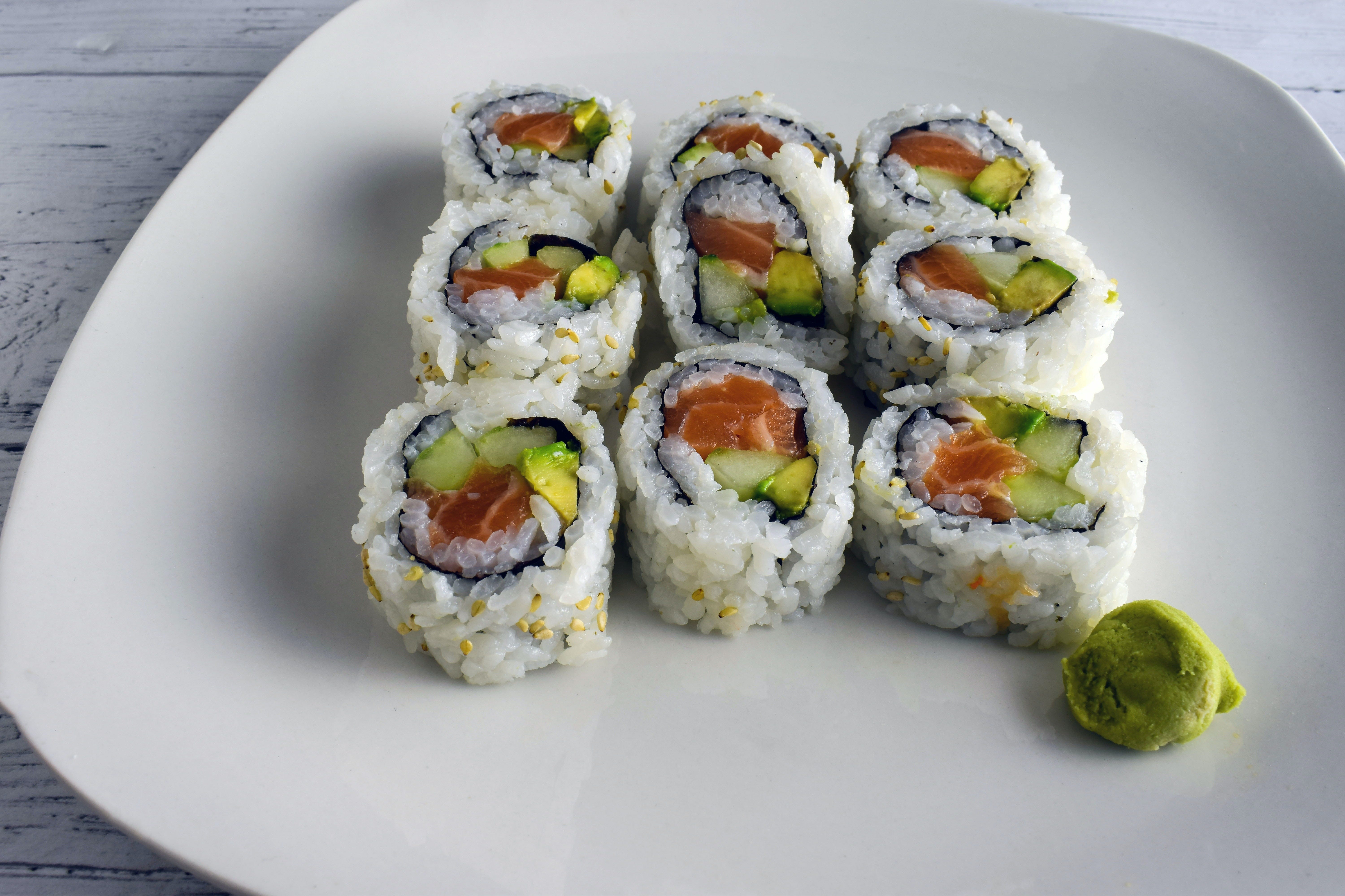 A plate holds several pieces of a California sushi roll.