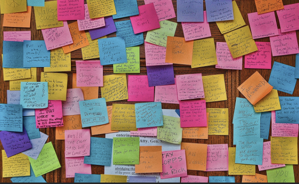 Board full of unorganized sticky notes