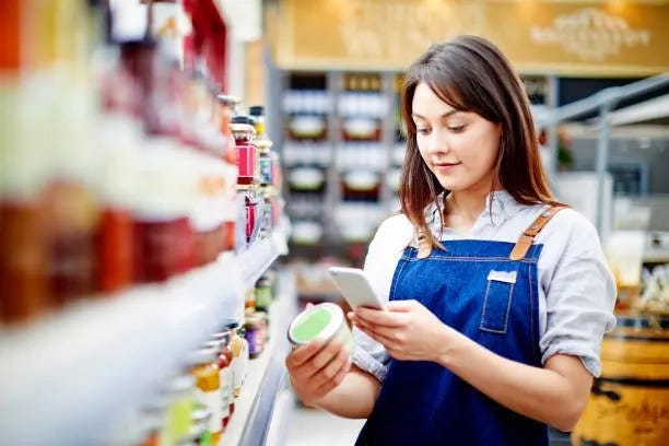 a supermarket employee manually scans a product on shelf
