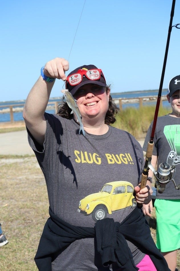 Family camper, nicole, hods up her catch after an afternoon fishing on Copano Bay