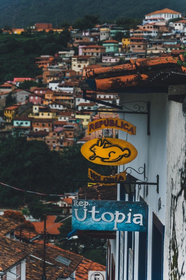 Houses in distance, with shop sign that says Republica Utopia
