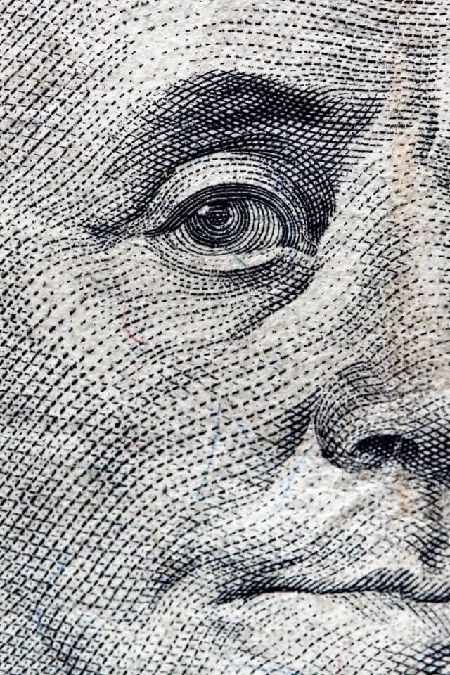 close up view of Benjamin Franklin’s face depicted on the one hundred dollar bill