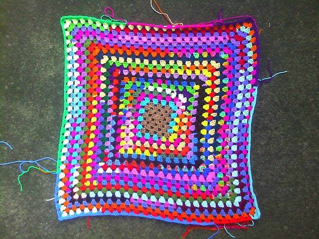 The first twenty-five rounds of a large, scrap yarn granny square