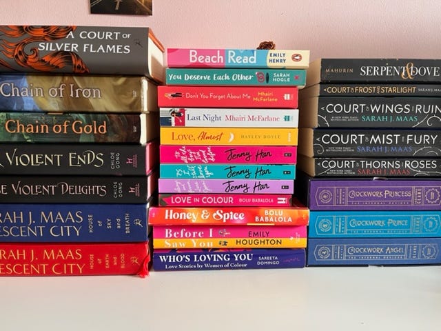 Three piles of books with mostly romance narratives.