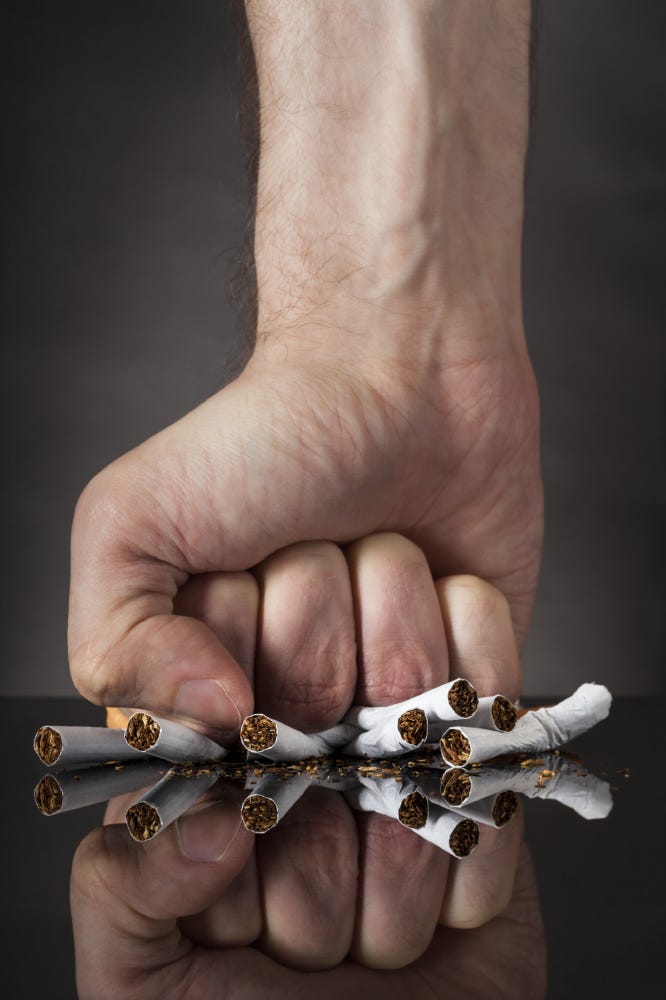 A man crushing cigarettes in determination to quit smoking