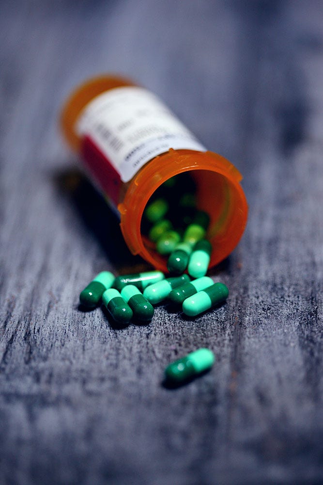 Bottle of green pill capsules.