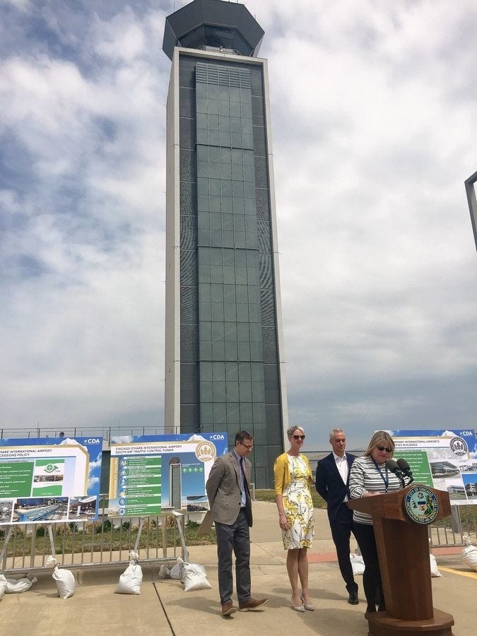 people giving a speech in front of the chicago o’hare international airport south air traffic control tower