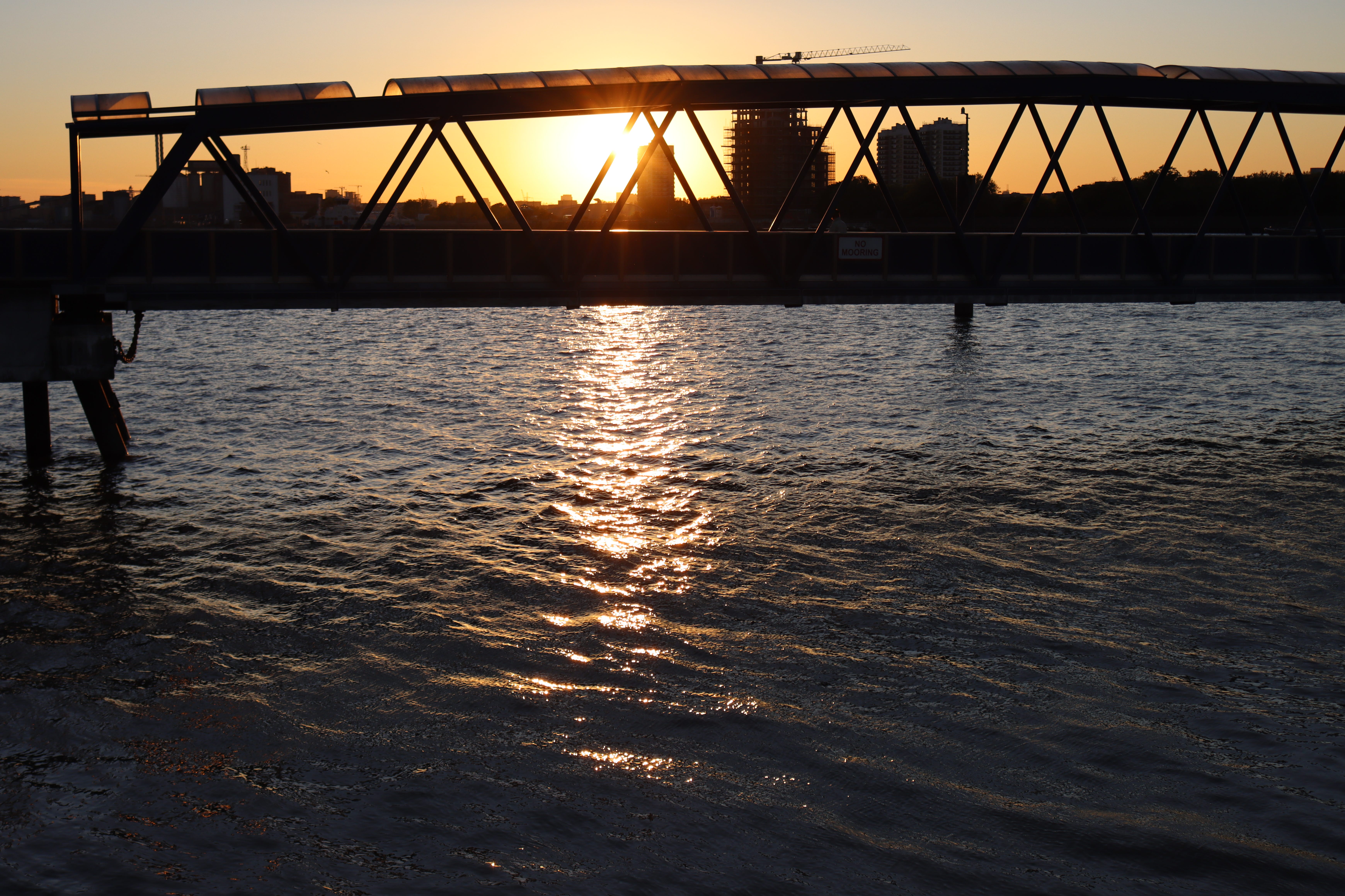 Sunset over the water with a bridge in silohuette