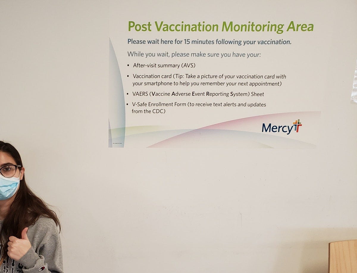 Young woman with mask thumbs up after getting vaccinated for coronavirus.