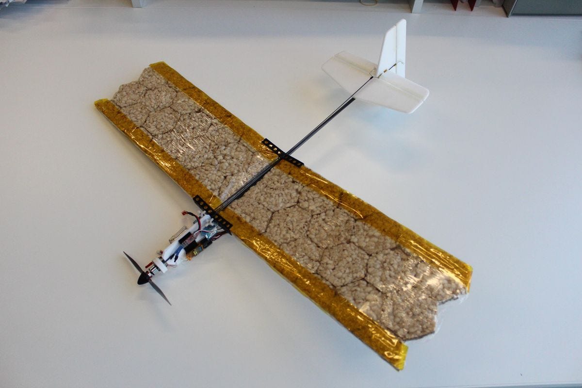 A picture of the edible drone. It looks like a toy airplane, with a small black propeller and white stabilizer wings at the end of the plane; the wings are long and wide and brown and visibly made of what looks like rice-cake material