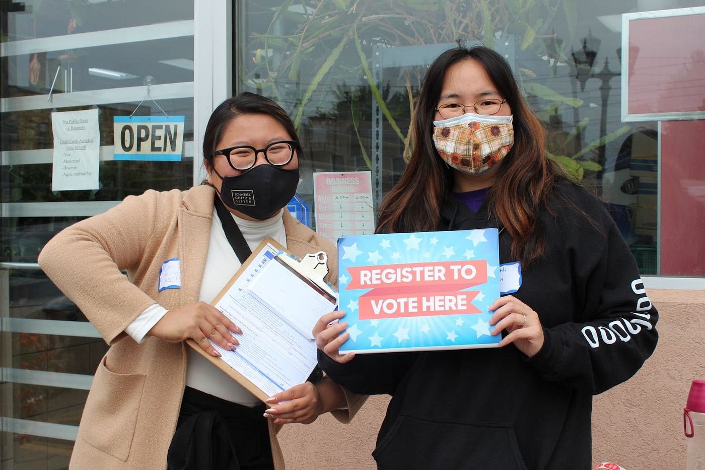 Volunteers Dieu and Elizabeth outside an Asian grocery store helping community members get registered to vote for National Voter Registration Day.