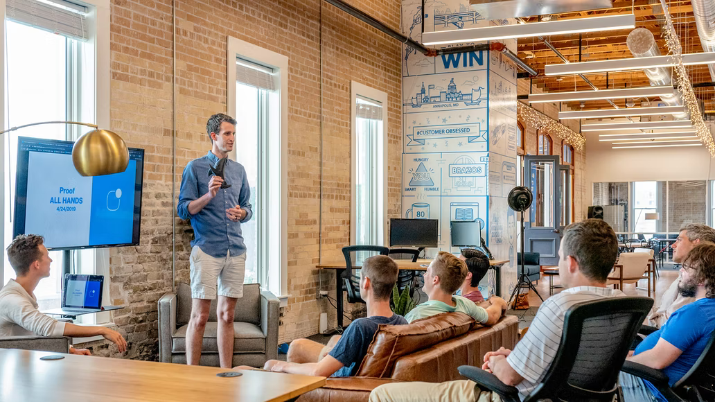 A man presenting in a meeting in front of his team