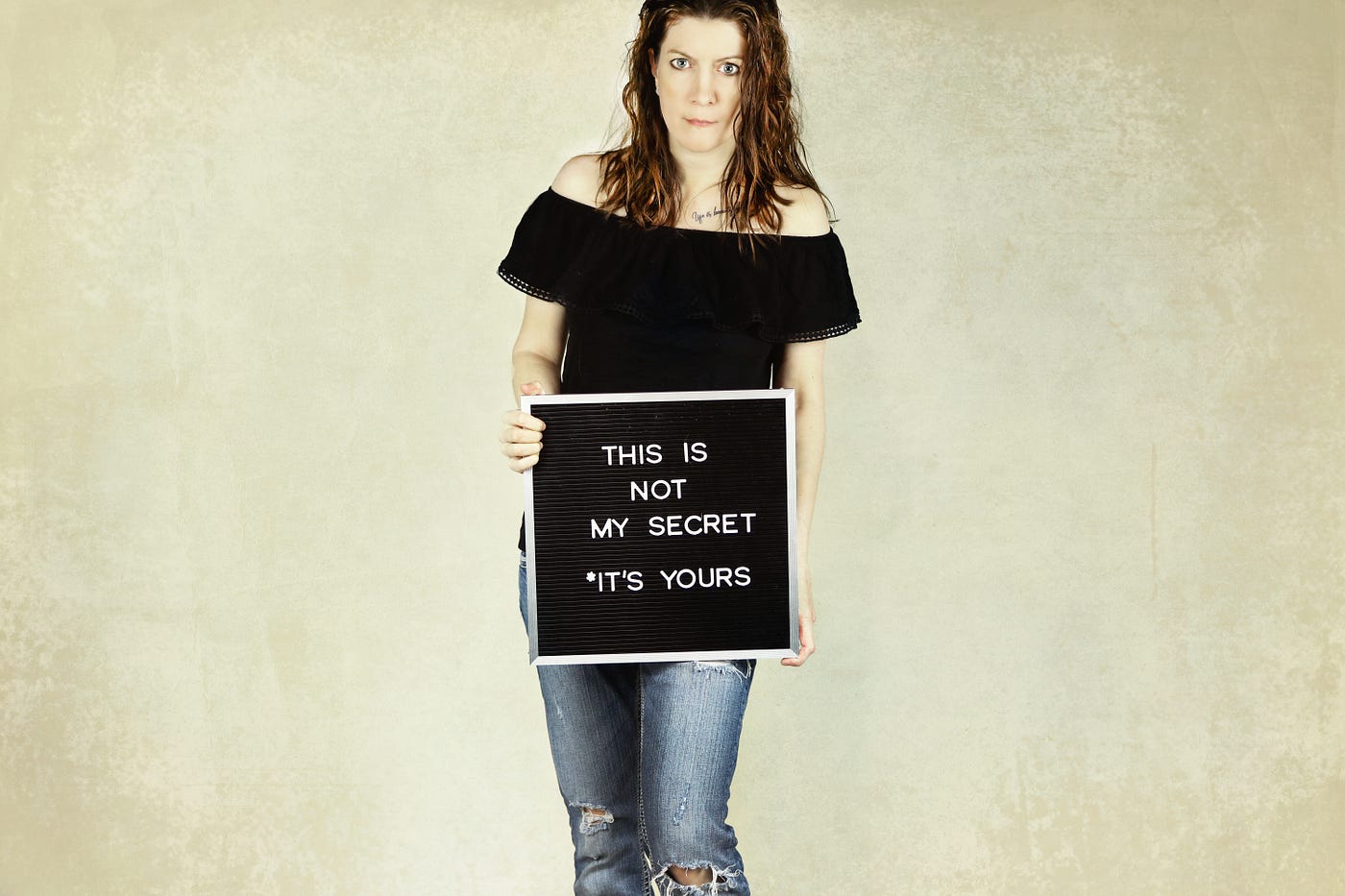 A person holds a sign saying “This is not my secret. *It’s yours.” #sexualassault #trauma #rape