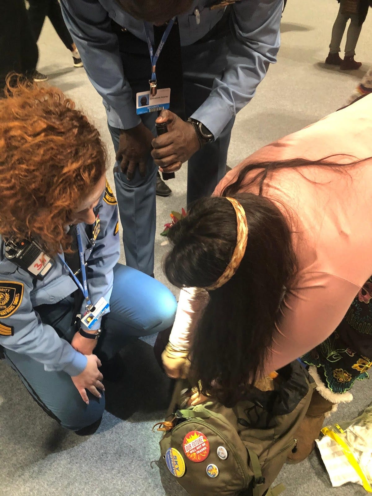 Activist Moneka de Oro opening her backback for two police officers at COP25.