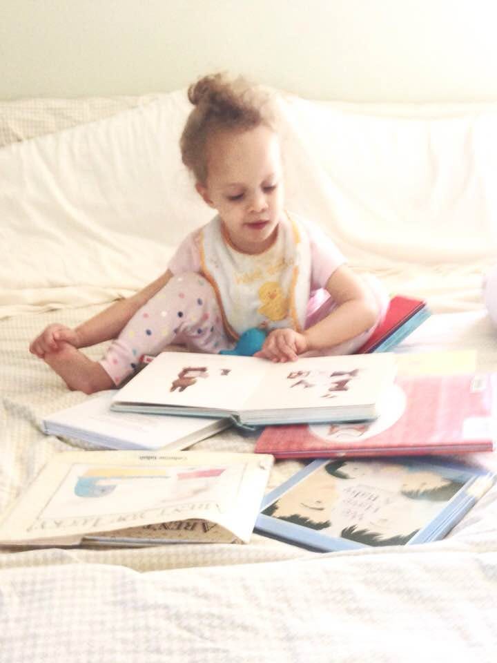 Emmy looking at books, shortly before her first diagnosis