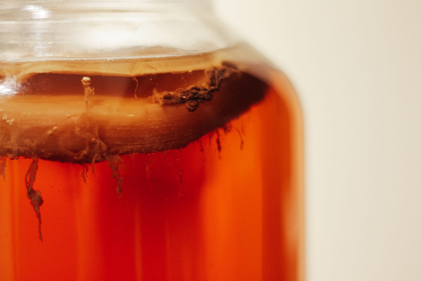 Close-up of a mason jar containing amber-colored kombucha.