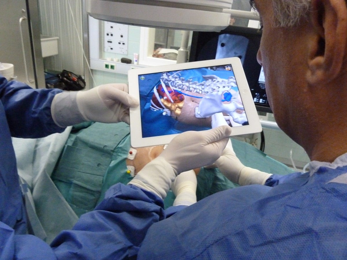 Surgeons planning a pedicle screw insertion with an AR projection of the patient’s 3-D spine model