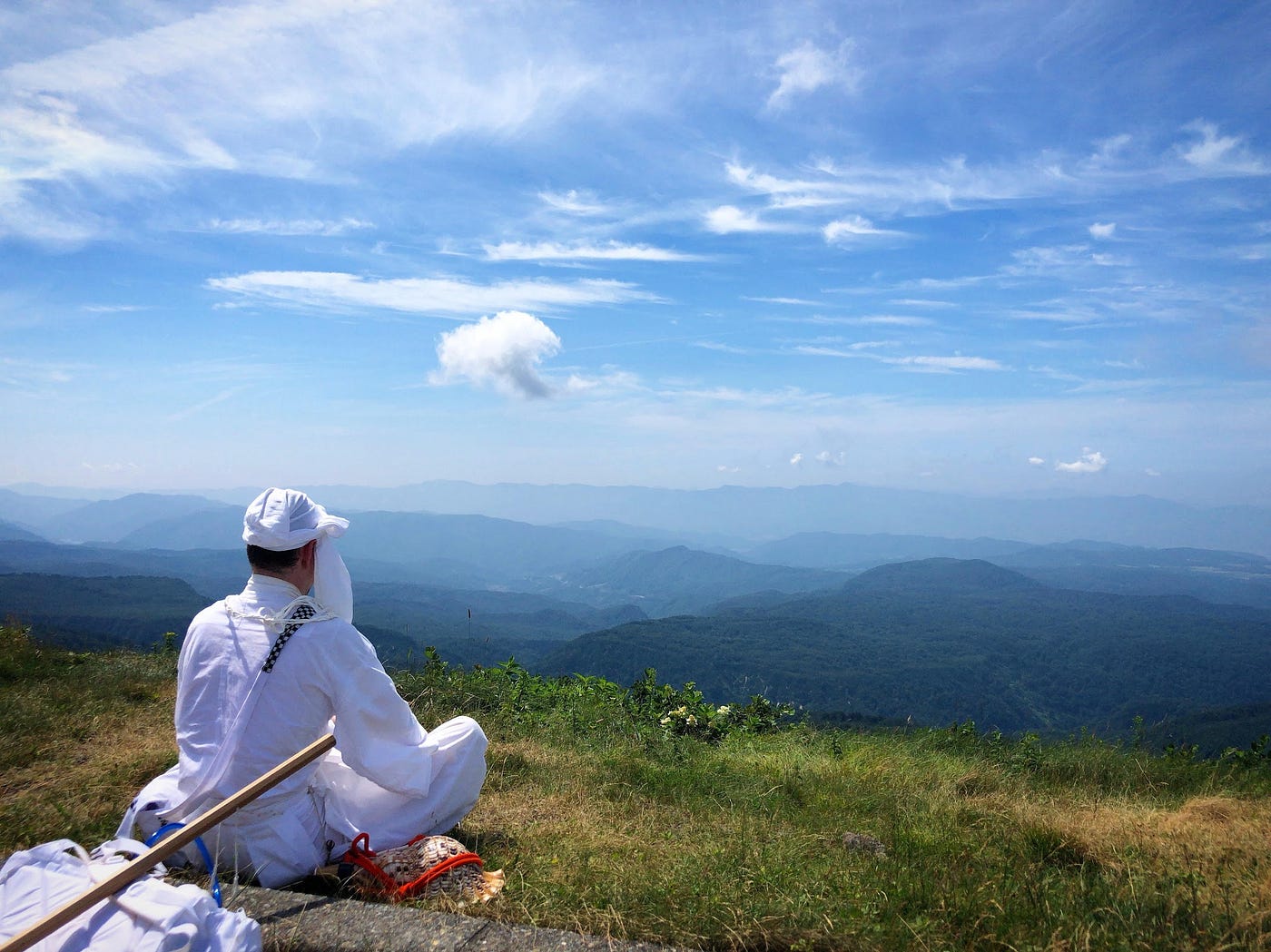 Tim Bunting Kiwi Yamabushi staring out over the blue sky and mountains of Gassan during Tokogatame, Yamabushi-style meditation.