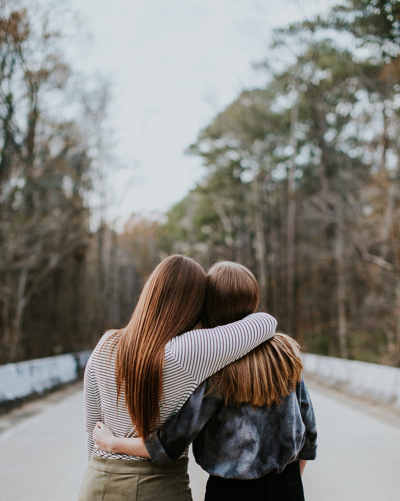 Two girls hugging each other.