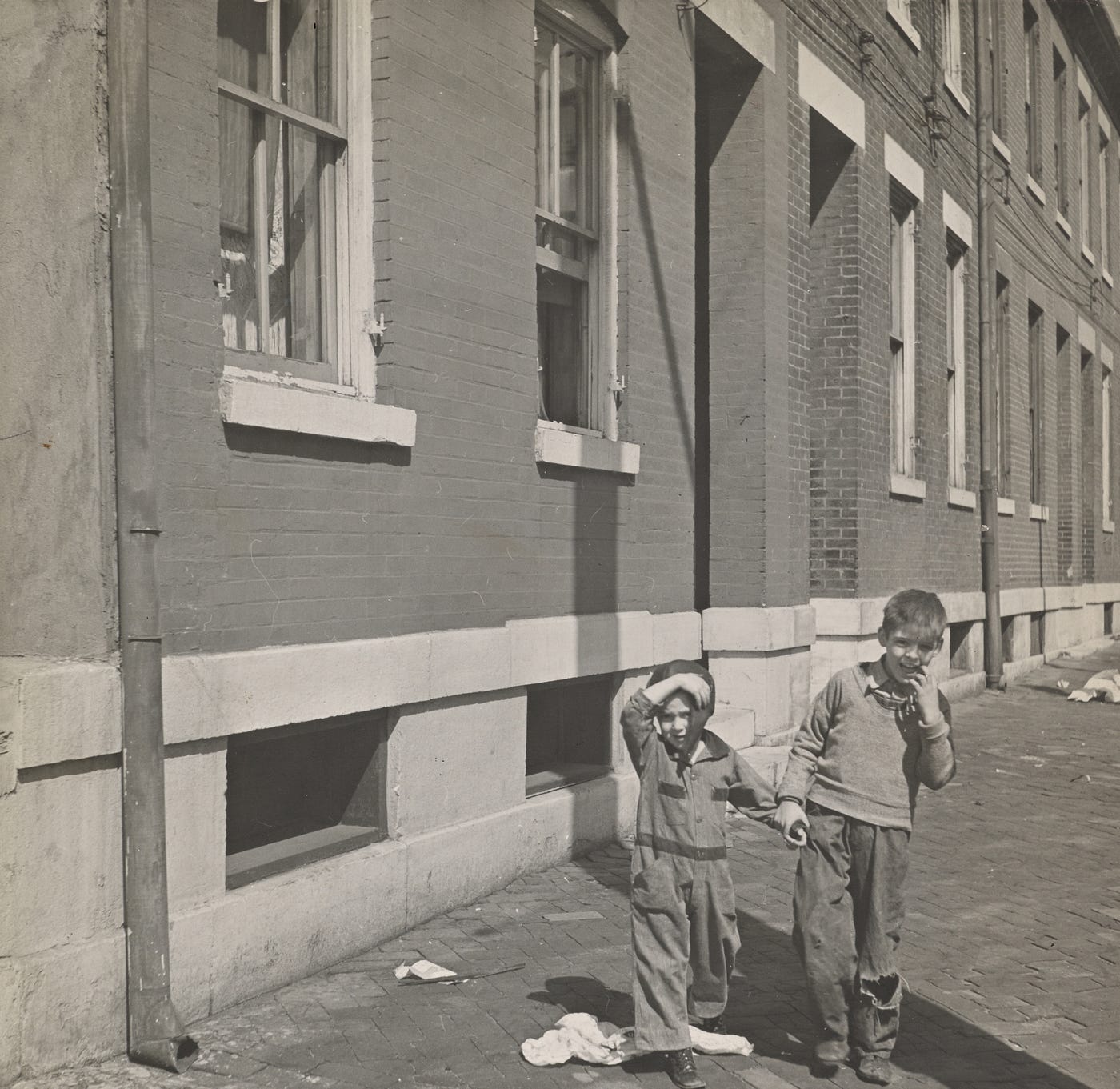 photo of two children standing outside a tenement building