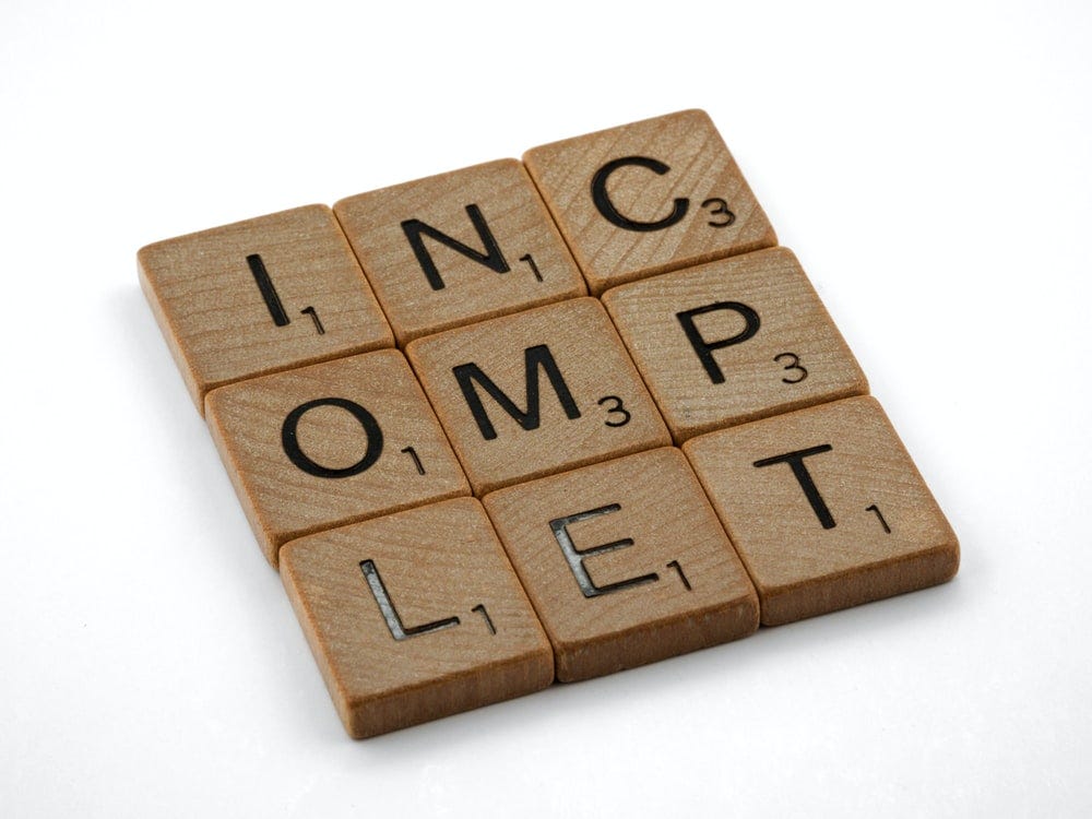 Scrabble tiles, jumbled, that spell the word Incomplet