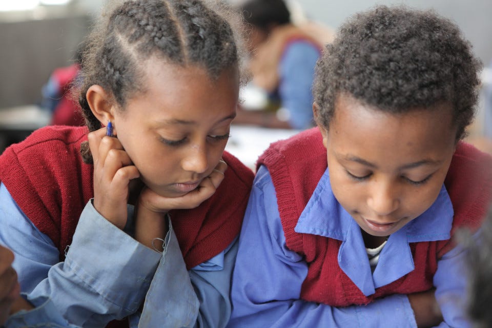 girl and boy reading together