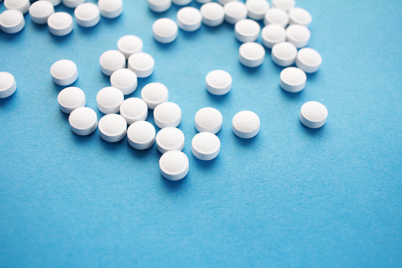 Many white pills (on a blue background).