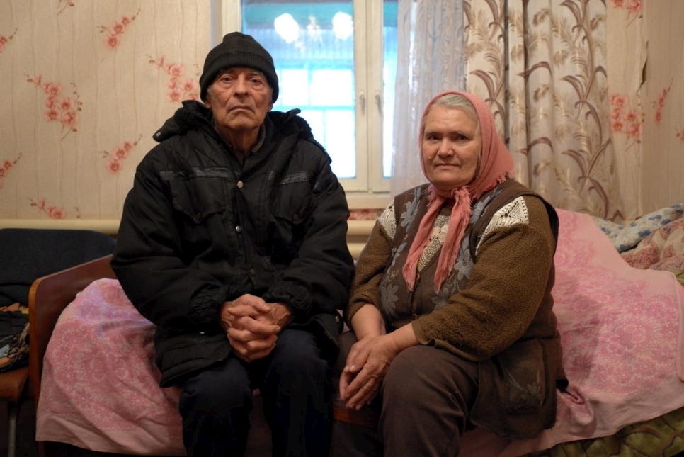 elderly couple sitting on bed