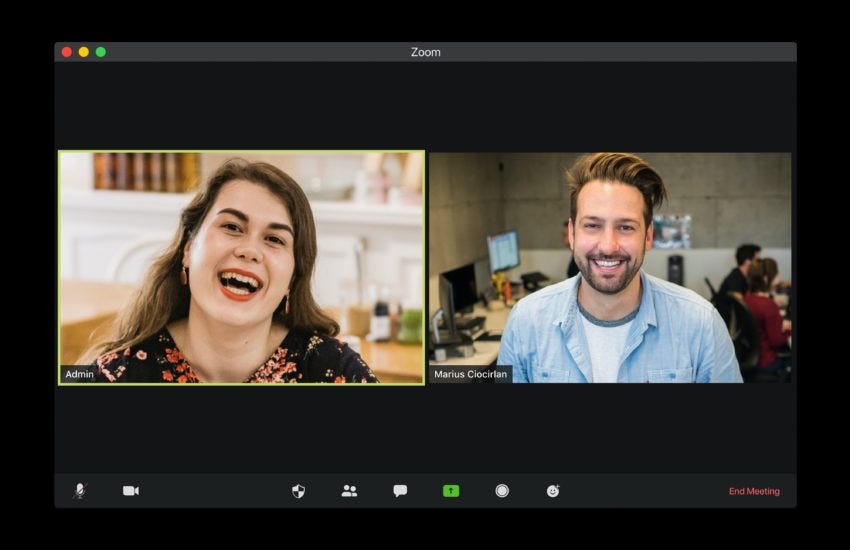 Screenshare view of two people smiling and having a meeting