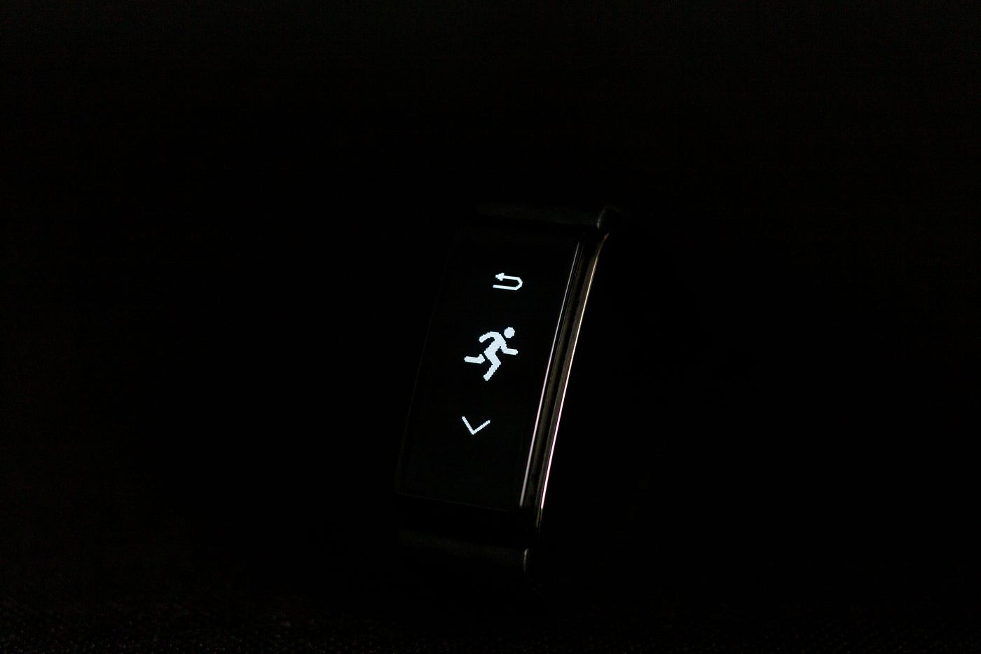 Narrow black pedometer shows a stick figure running. The image is in black and white.