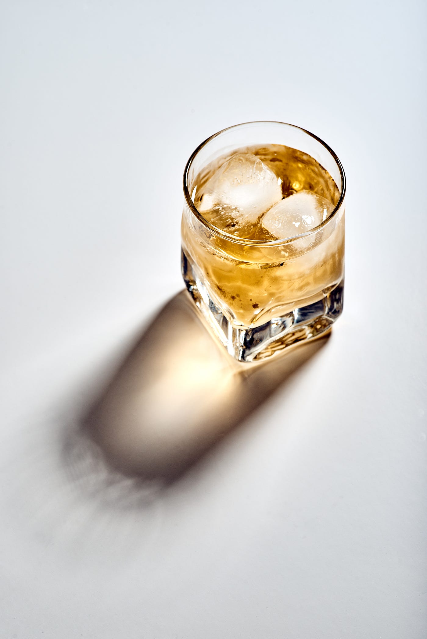 Amber-colored alcohol fills a small clear glass. Reducing heavy alcohol consumption (to moderate or none) is one of the natural ways to drop your blood pressure.