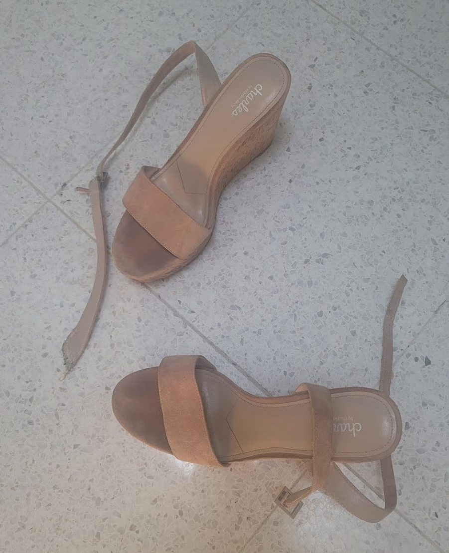 Tan wedge heels with a broken strap.