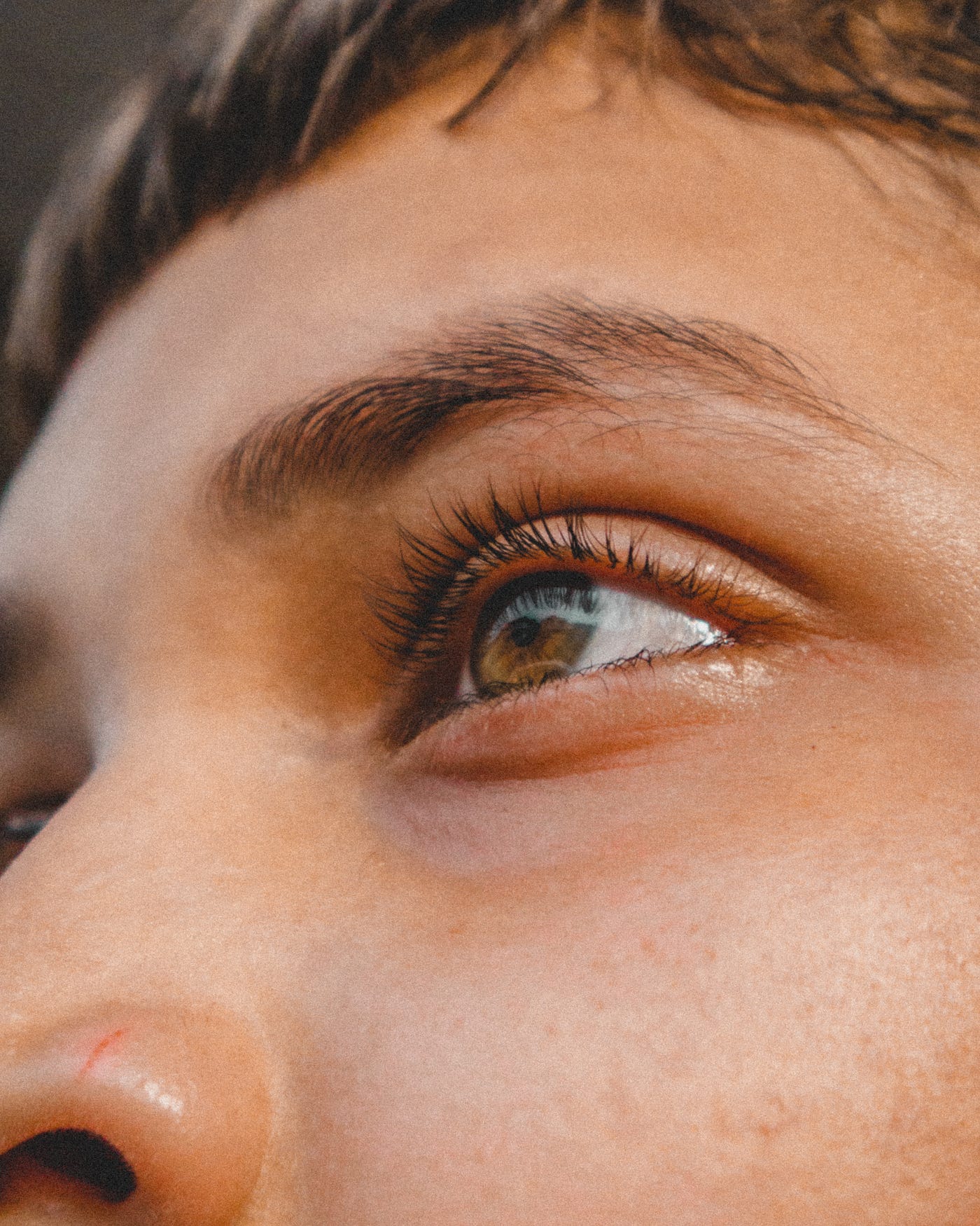 Woman’s left brown eye (and surrounding face) in close-up.