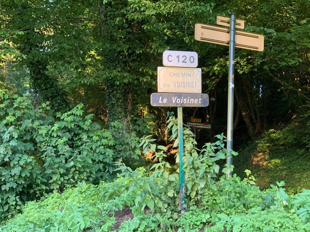 Photo des panneaux de circulation indiquant la route “C120”, la voie “Chemin du Voisinet” et le lieu-dit “Le Voisinet”