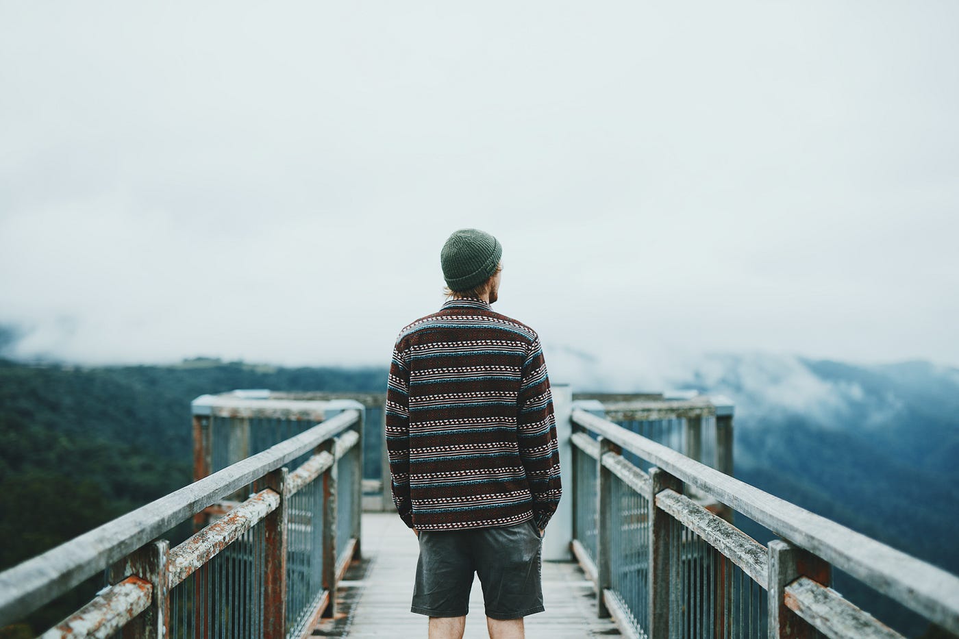 “A man in a beanie on an observation deck looking 