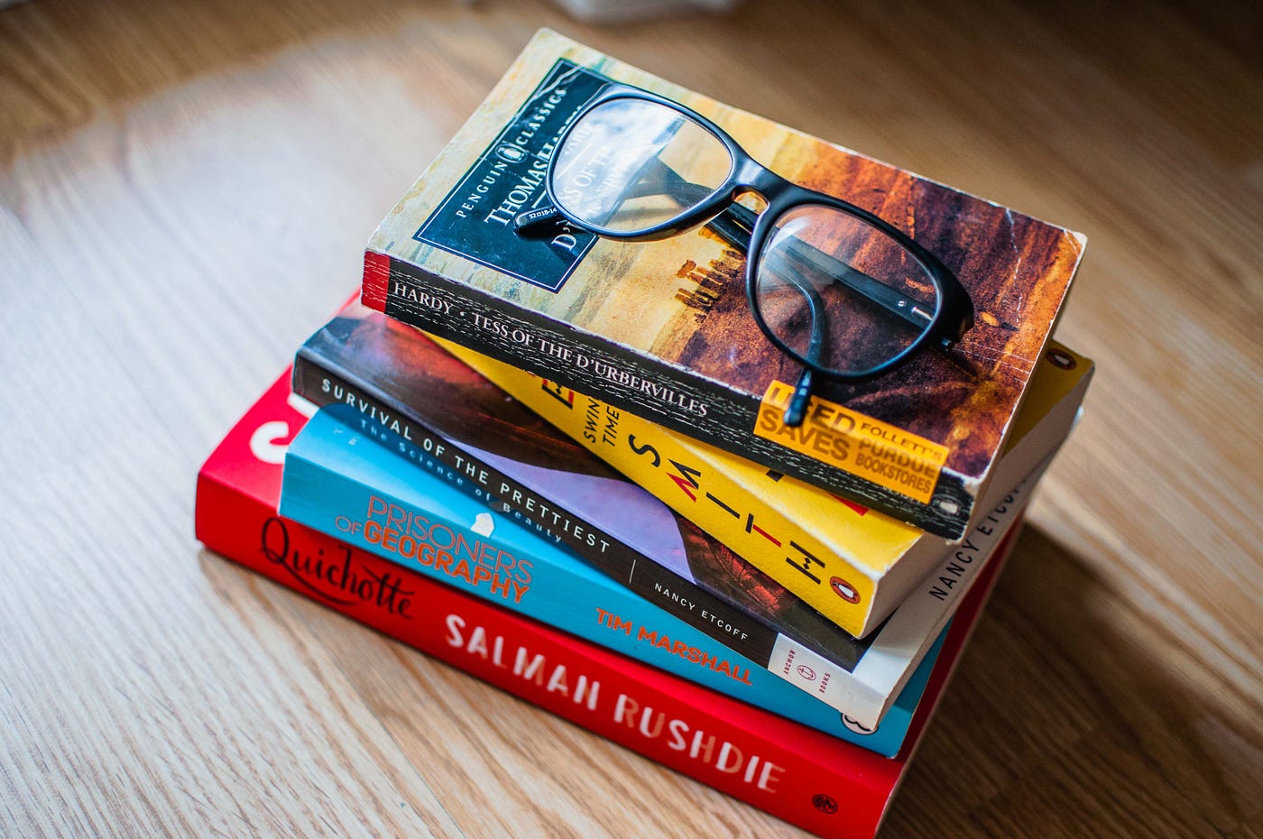 a stack of books with glasses on top