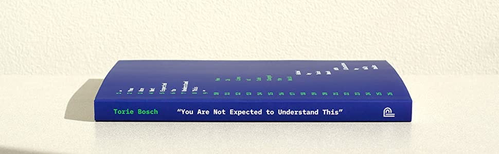 A photo of the cover of “You Are Not Expected To Understand This”; it is blue and lying on its side, with the spine facing the viewer. The editor’s name, Torie Bosch, is in a green monospaced font; the title is in a white monospaced font