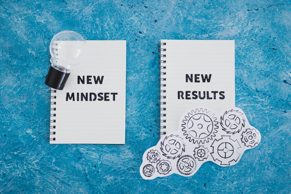 otepad with New Mindset New Results text with light bulb and gearwheel mechanism. The image indicates the mindset shift needed to save better.