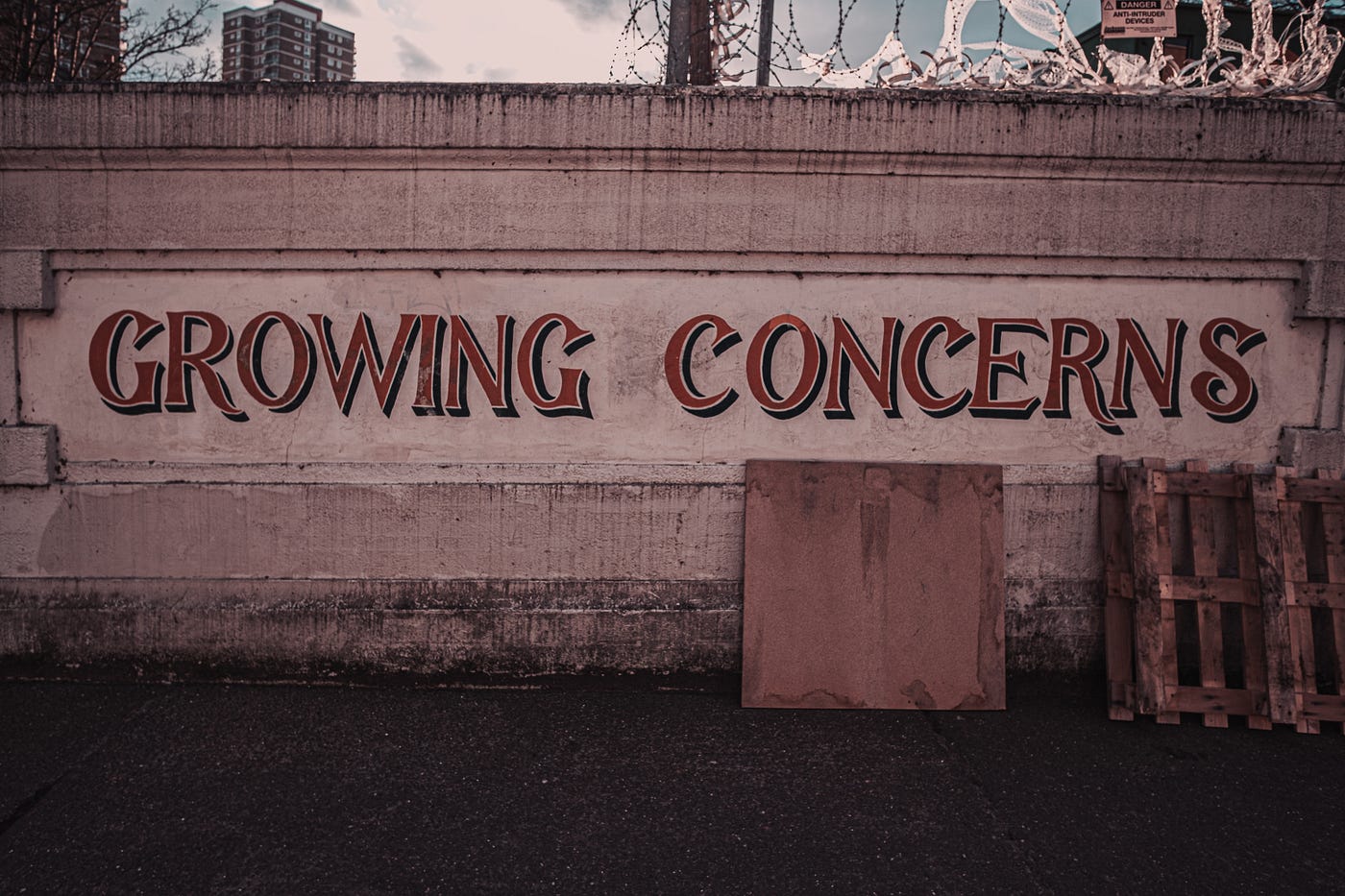 A picture of a wall with the words “Growing Concerns” painted in red. More Money, More Problems. Mackenzie Plunkett. Hawaii. Hawaii. Culture. Indigenous. Native.