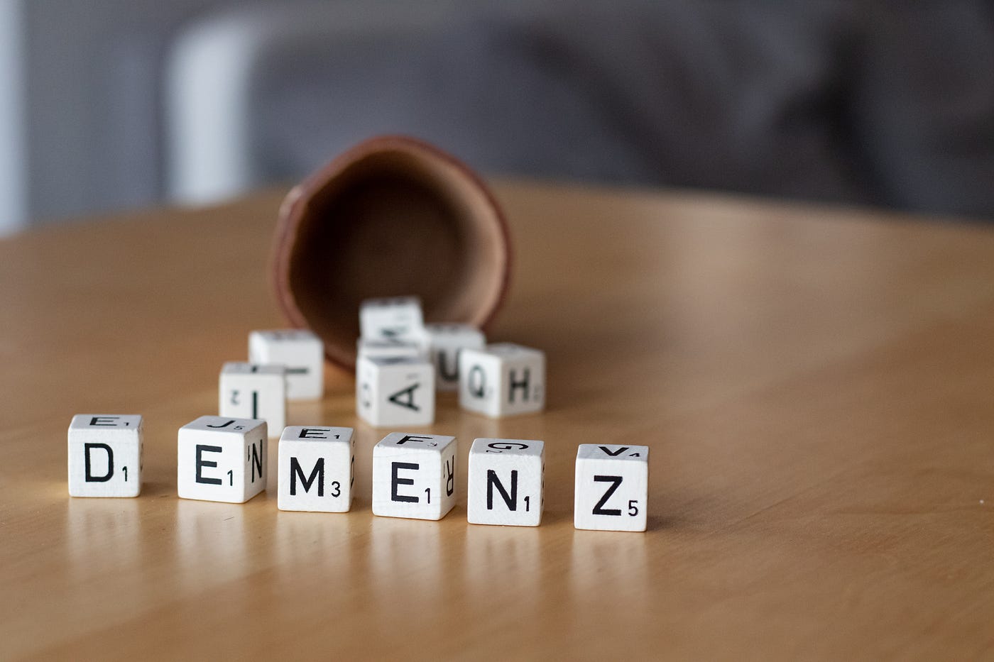 Scrabble cubes spelling out “DEMENZ”