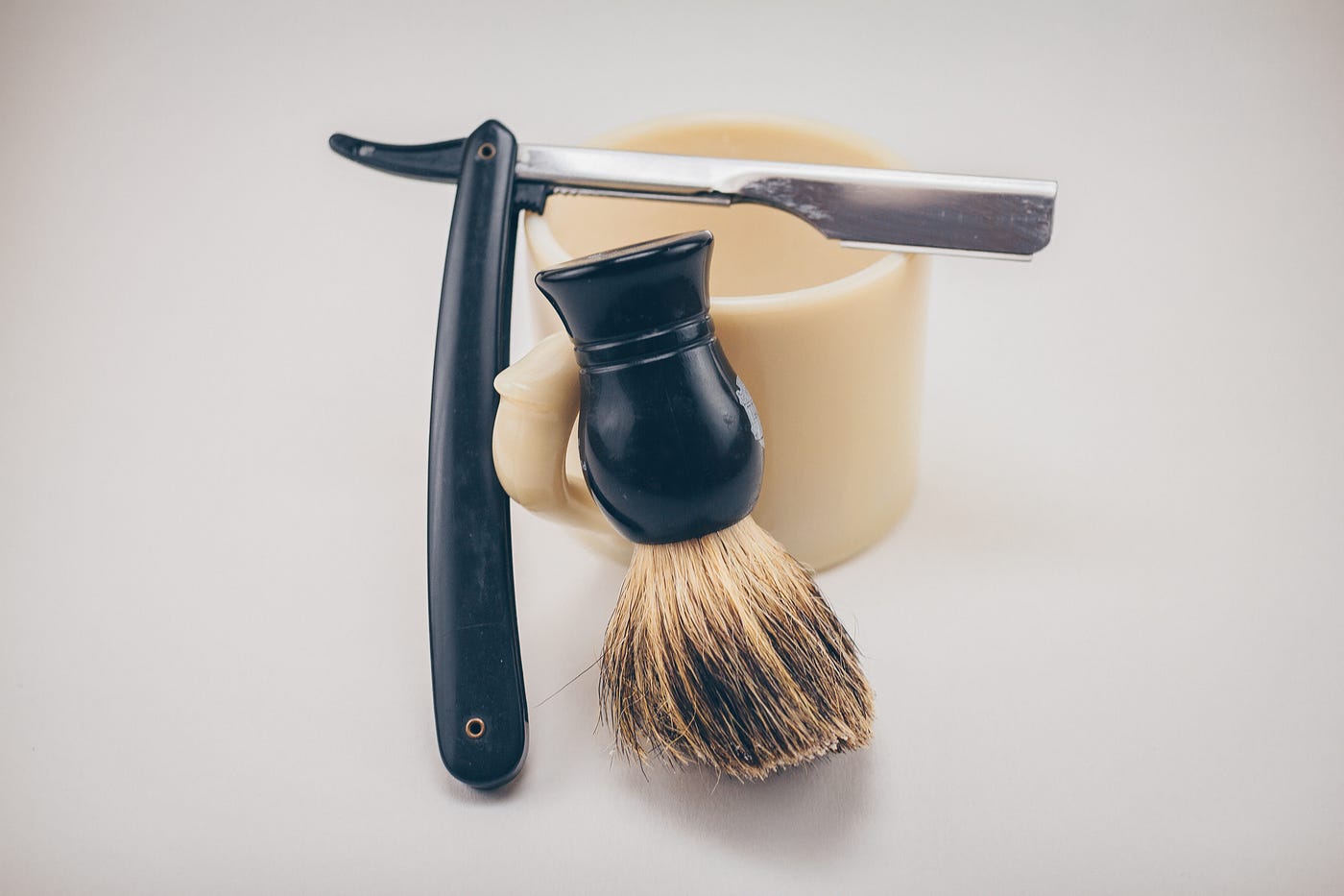 An image of a shaving brush and a shaving knife, barber style.