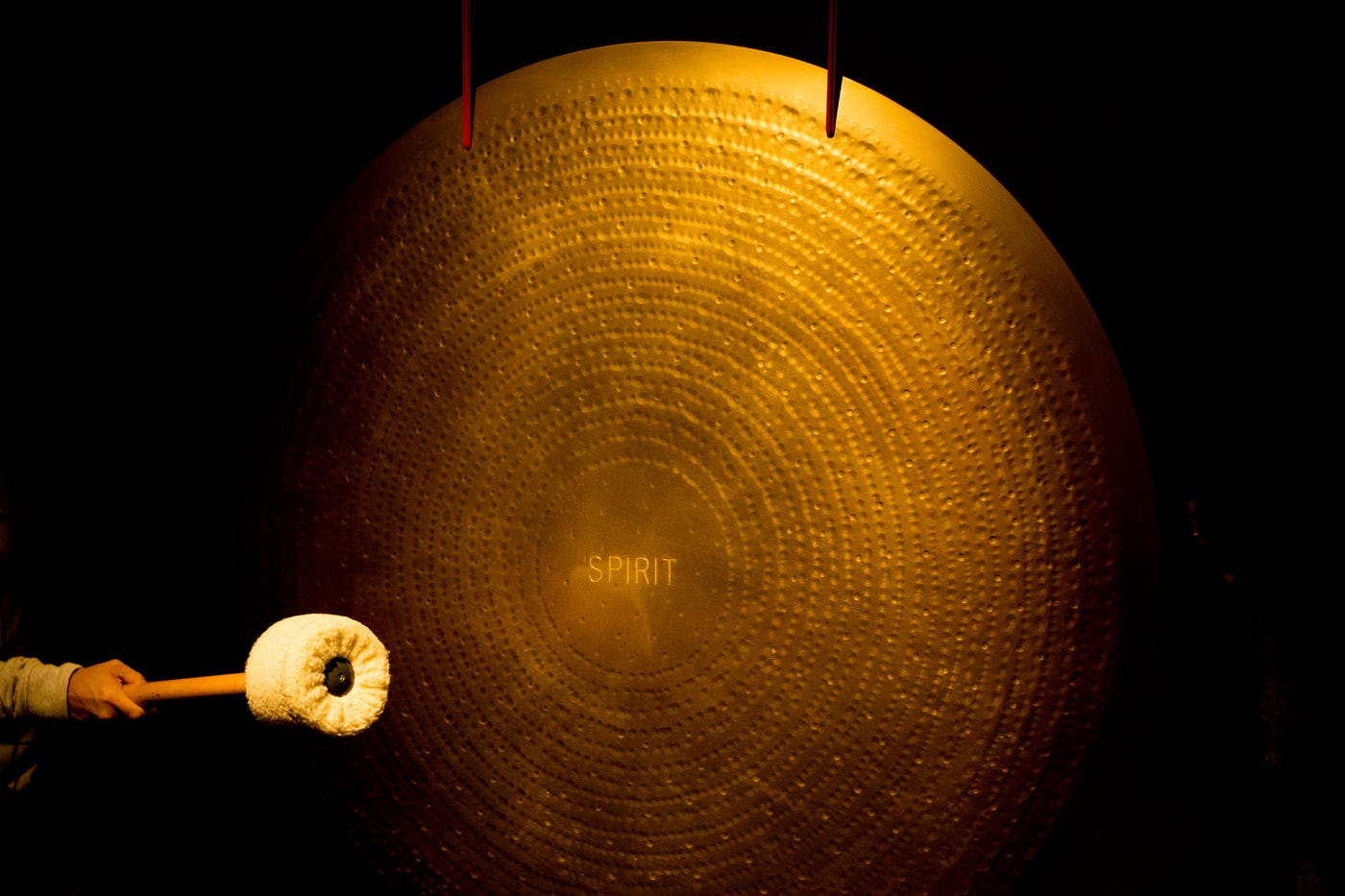 a large golden gong with the word spirit engraved in the center.