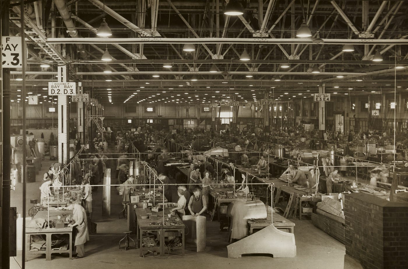 Black and white photo of manufacturing assembly lines circa 1940s.