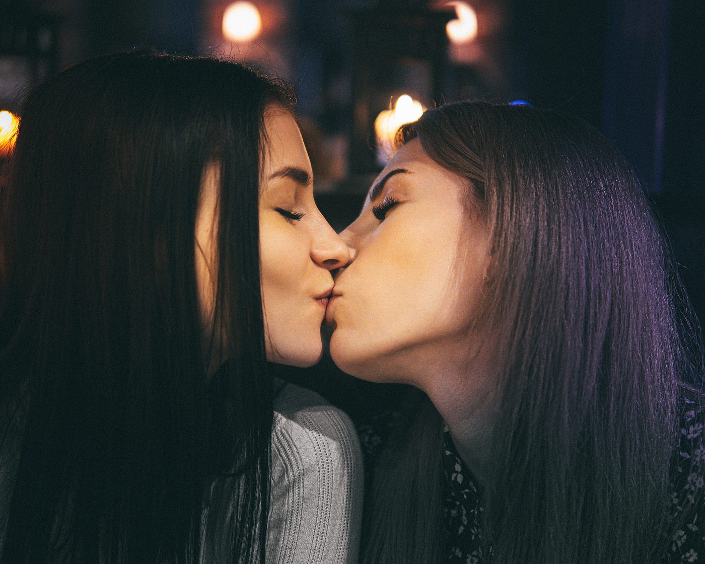 Two women are kissing with outdoor lights behind them. #lesbians #twogirlsk...