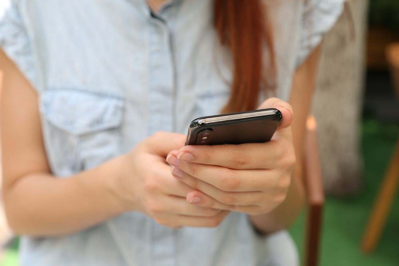 person looking at a smartphone they're holding in their hands