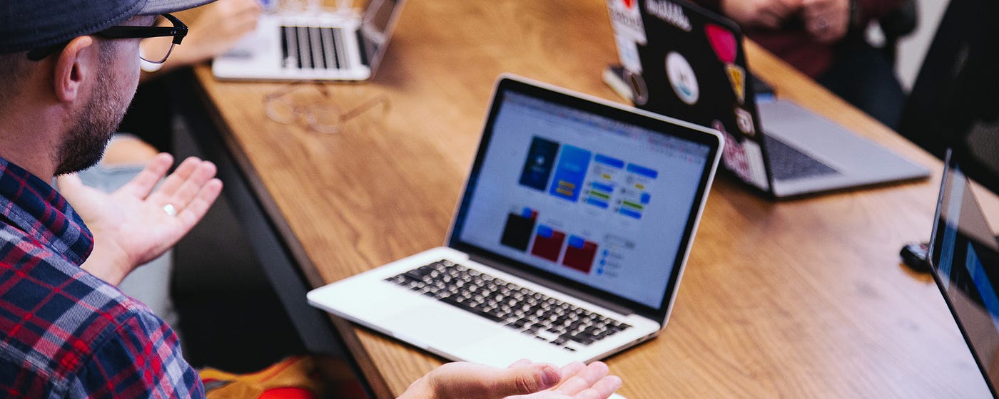 A designer is talking with stakeholders to understand their needs and business objectives better.