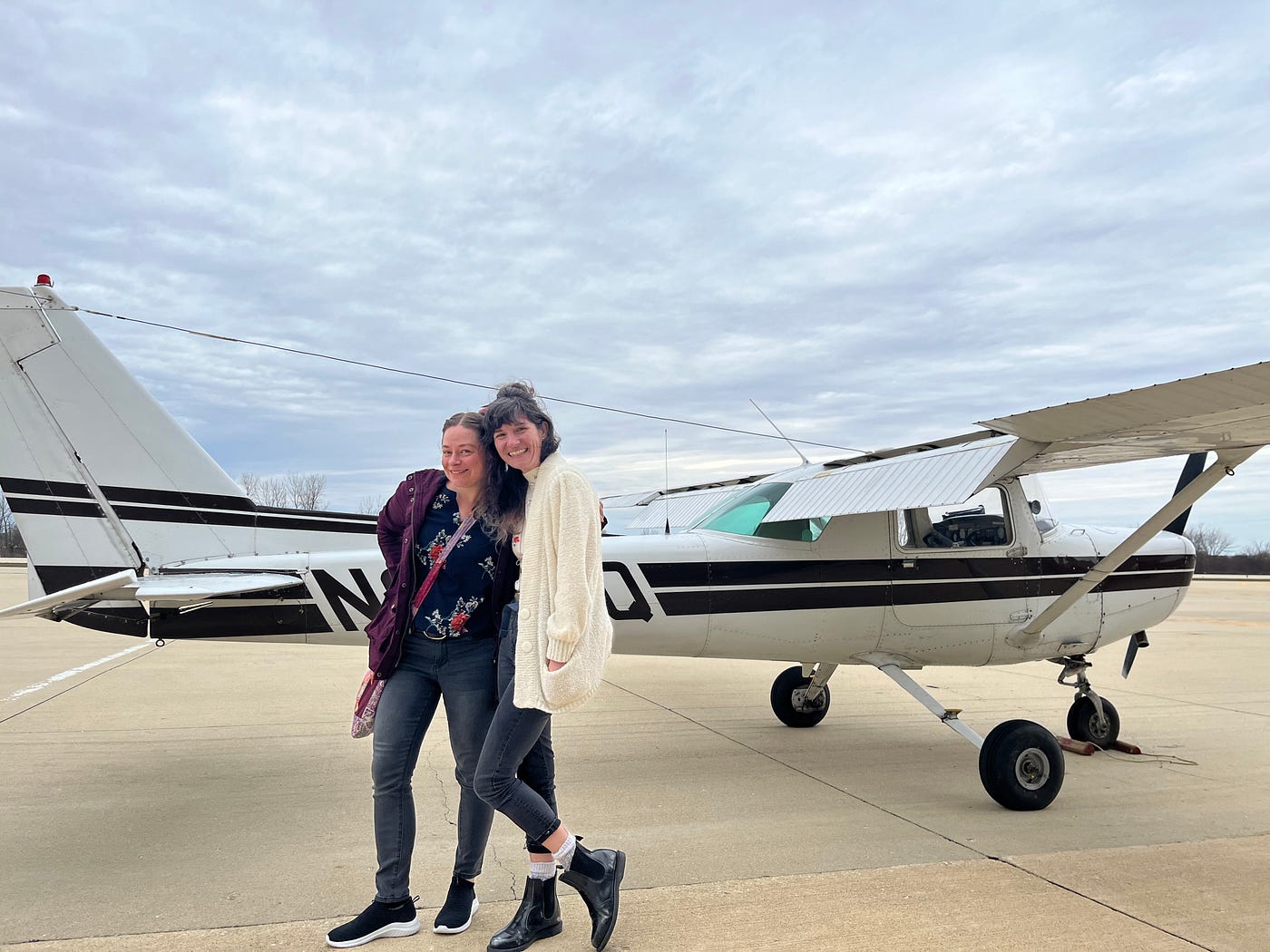 two women in front of a small plane